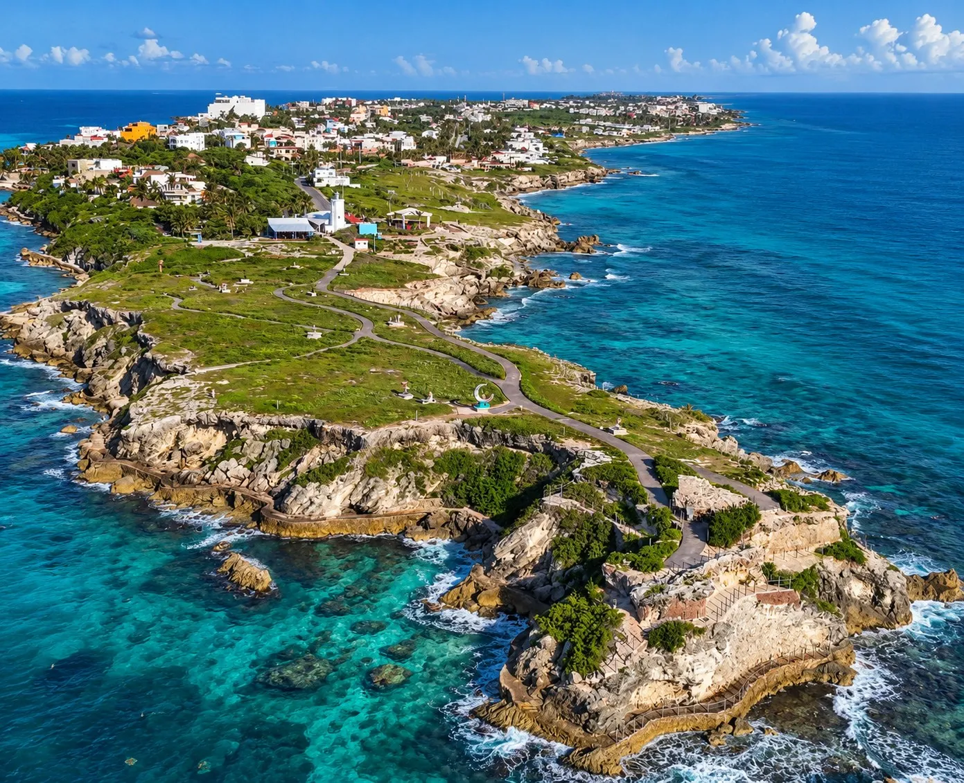 Vista aérea de Punta Sur, en Isla Mujeres, con el faro, el sendero costero y los acantilados sobre el mar turquesa
